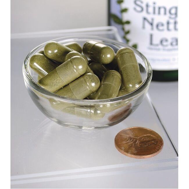 Swanson Stinging Nettle Leaf - 400 mg 120 capsules, known for their nutritional values, are placed in a bowl next to a penny.