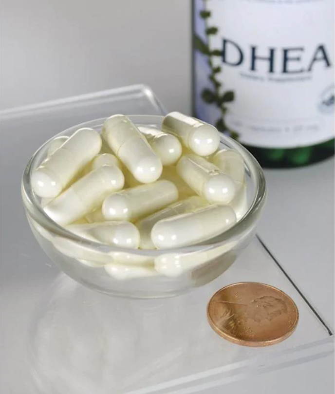 A bottle of Swanson DHEA - High Potency - 25 mg 120 capsules in a bowl next to a penny.