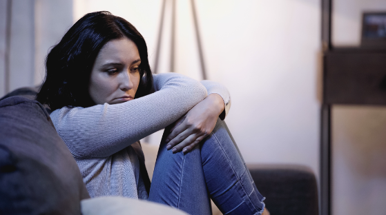 Unhappy woman sulking on couch