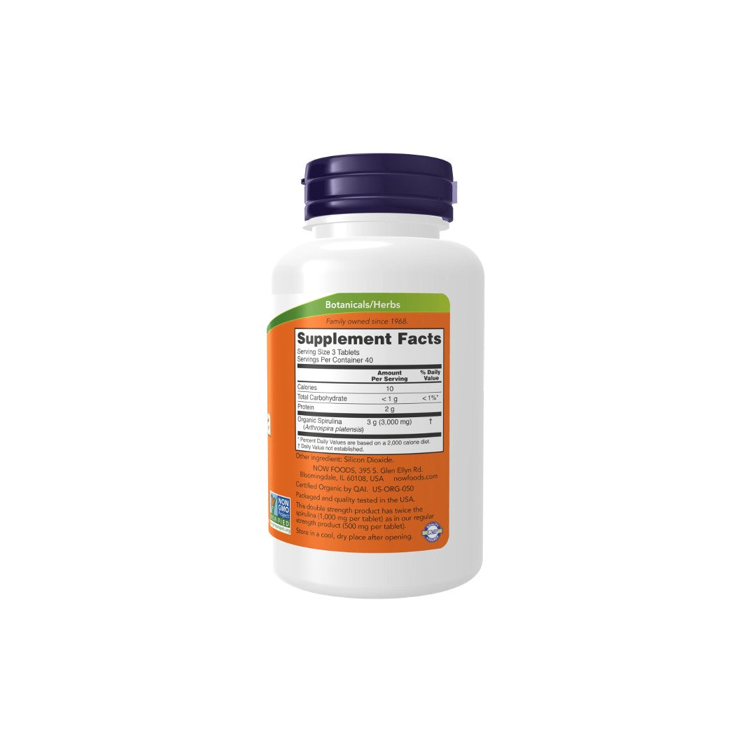 A white bottle of Now Foods Organic Spirulina Double Strength supplement, displaying a green nutritional facts label and orange branding on the front.