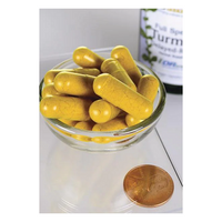 Thumbnail for A glass bowl overflowing with yellow capsules sits next to a penny for scale, as a Swanson Turmeric 750 mg 60 Veggie EMBO Caps AP bottle is visible in the background.