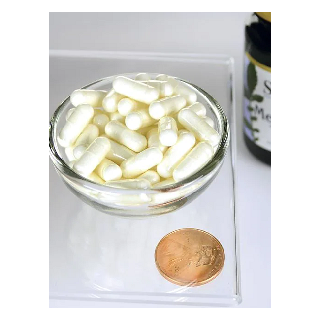 A clear glass bowl filled with Swanson's Melatonin 3 mg capsules next to a penny, with a partially visible bottle in the background, indicating its purpose in sleep regulation and jet lag relief.