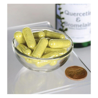 Thumbnail for A small glass bowl filled with green capsules sits beside a coin for scale, emphasizing their compact size. In the background, a Swanson 