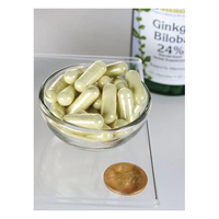 Thumbnail for A small glass bowl holds several beige capsules next to a penny for scale. In the background, a bottle labeled 