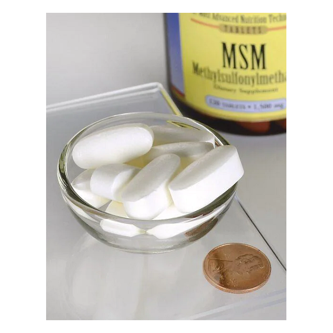 A small glass bowl holds large white tablets beside a penny for scale. A partially visible bottle labeled "Swanson MSM" in the background hints at this organic sulfur product, often used for joint health.