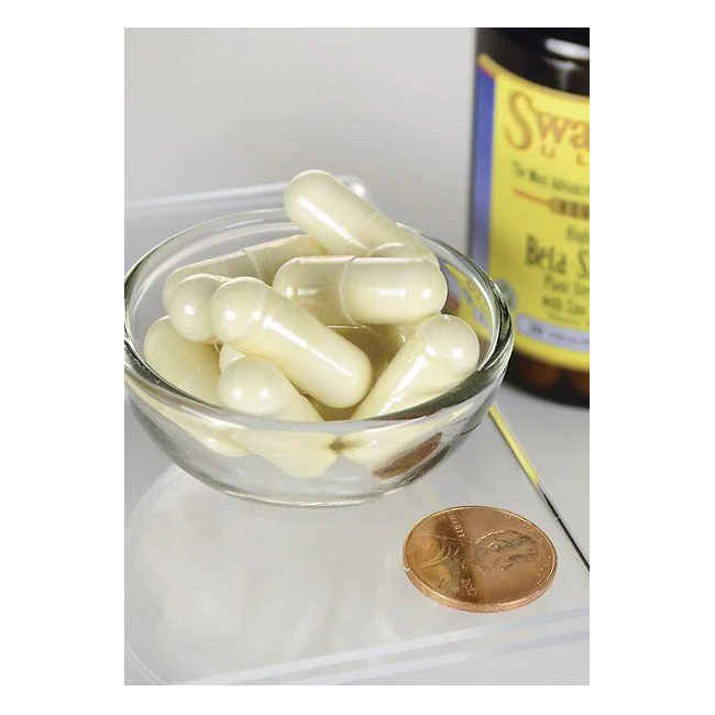 A bowl with Swanson Beta-Sitosterol 320 mg veggie capsules, known for promoting heart health, sits next to a penny with a partially visible bottle in the background.