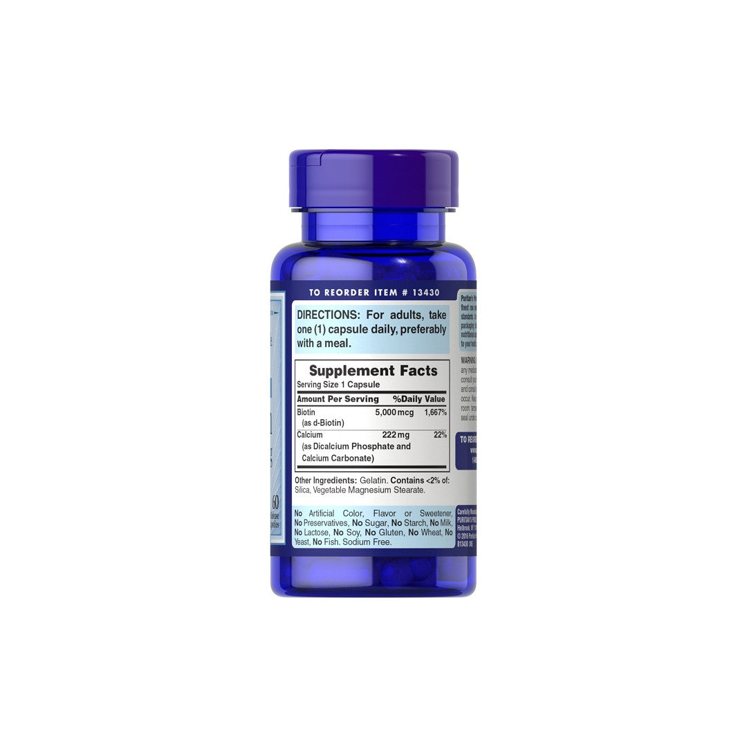 A dietary supplement bottle of Puritan's Pride Biotin 5000 mcg for hair growth, on a white background.