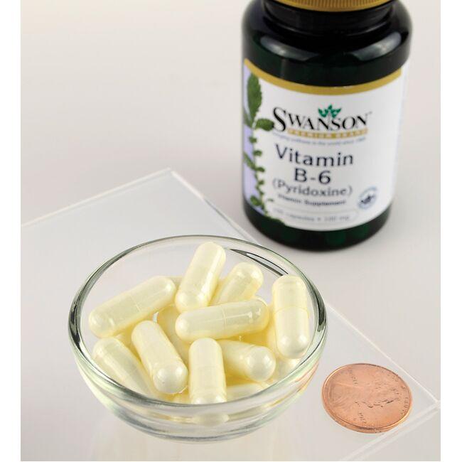 Swanson Vitamin B6 Pyridoxine capsules, are shown next to a glass of water.