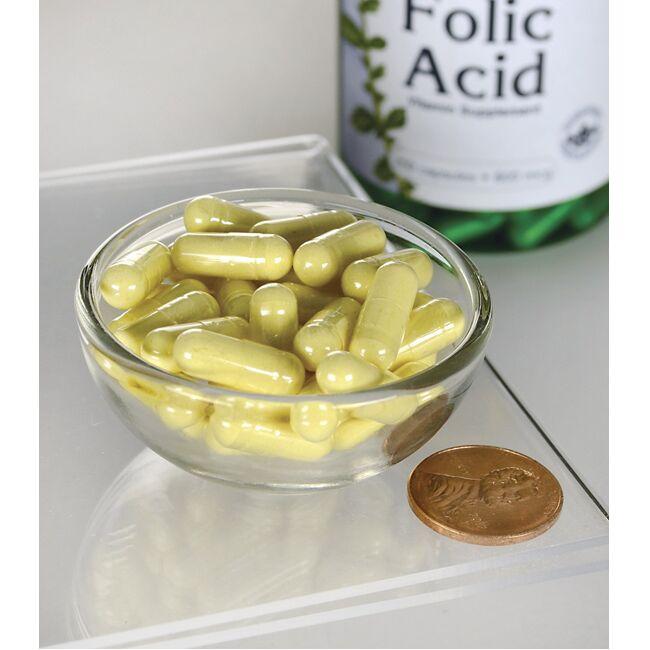 A bowl of Swanson's Folic Acid - 800 mcg 250 capsules with a coin next to it.