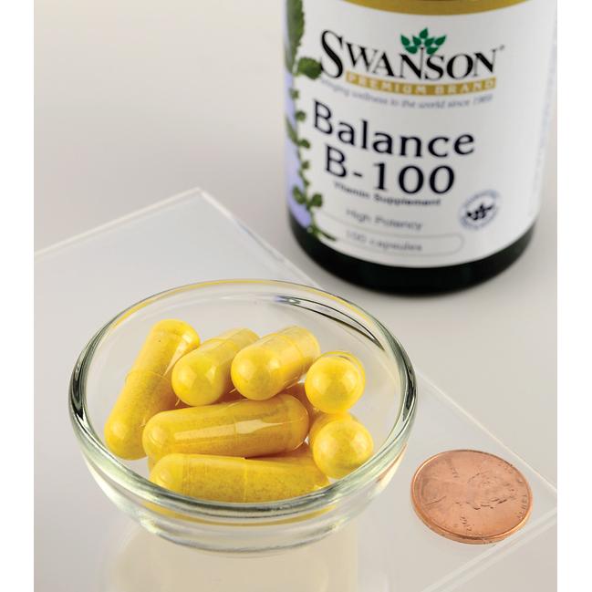 A bottle of Swanson Vitamin B-100 Complex - 100 capsules, a supplement rich in B-family vitamins, essential for energy metabolism and cardiovascular maintenance, with a penny next to it.