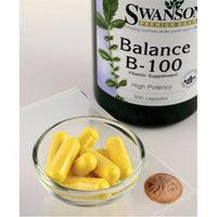 Thumbnail for A bottle of Swanson Vitamin B-100 Complex - 300 capsules, promoting cardiovascular health and immune health, with a coin next to it.