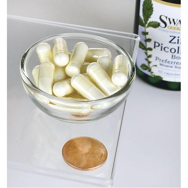 A bowl of Swanson Zinc Picolinate - 22 mg 60 capsules next to a penny, promoting zinc for immune system and prostate health.