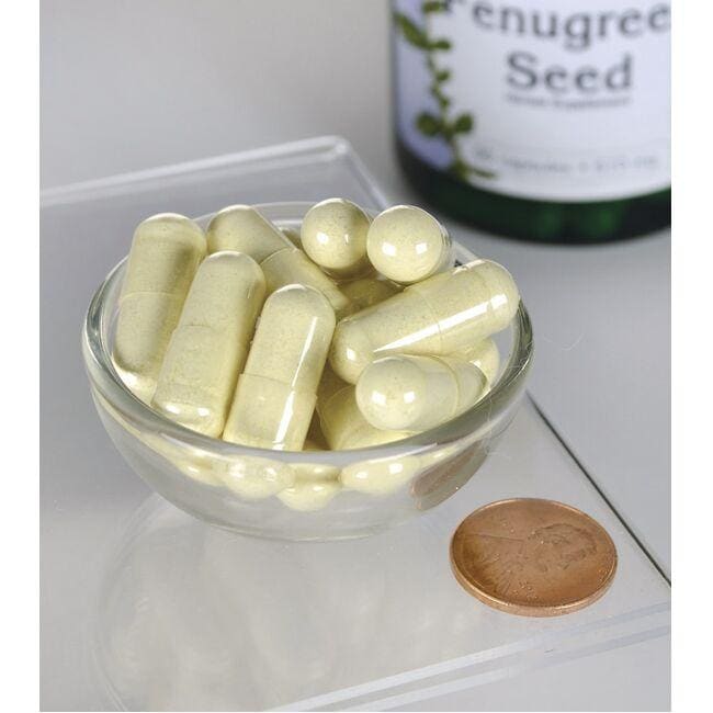 A bottle of Swanson Fenugreek Seed - 610 mg 90 capsules is next to a bowl of capsules.