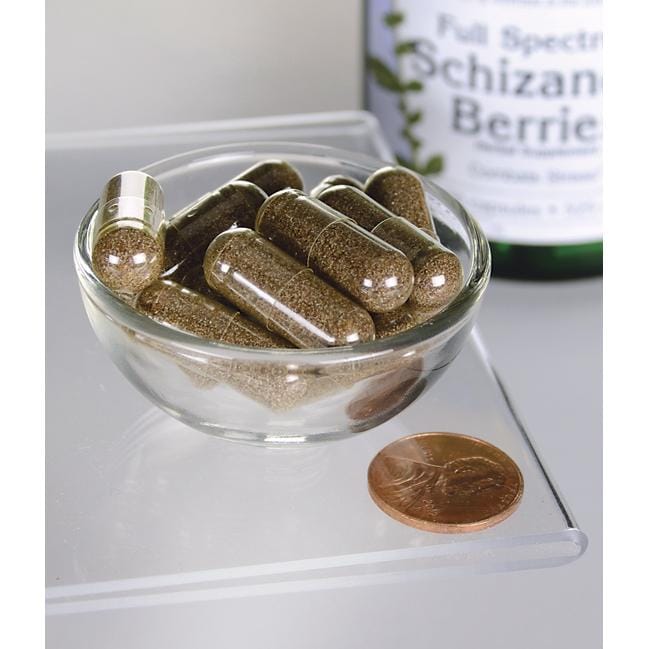 Swanson's Schizandra Berries - 525 mg 90 capsules, a liver tonic and adaptogen, are showcased in a bowl next to a penny.