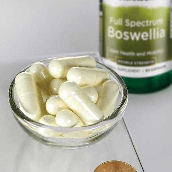 A dietary supplement, Swanson Boswellia, is showcased with 60 capsules next to a penny on a scale.