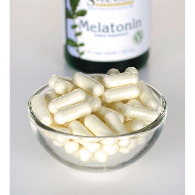Swanson Melatonin - 0,5 mg 60 vege capsules in a glass bowl next to a bottle.