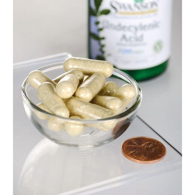 A bottle of Swanson's Undecylenic Acid - 60 vege capsules, promoting GI tract wellness, with a penny next to it.