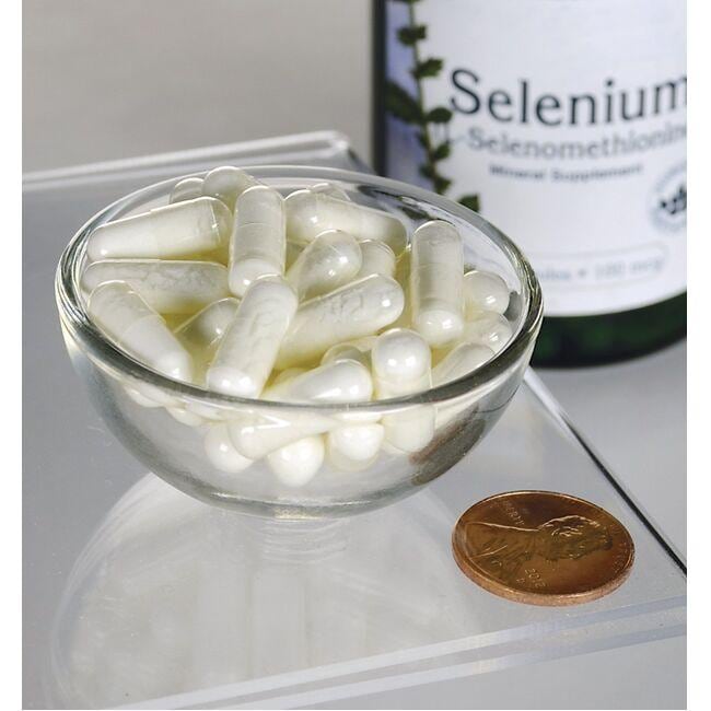 Swanson Selenium - 100 mcg 200 capsules L-Selenomethionine in a bowl next to a penny, offering antioxidant support for cardiovascular health.