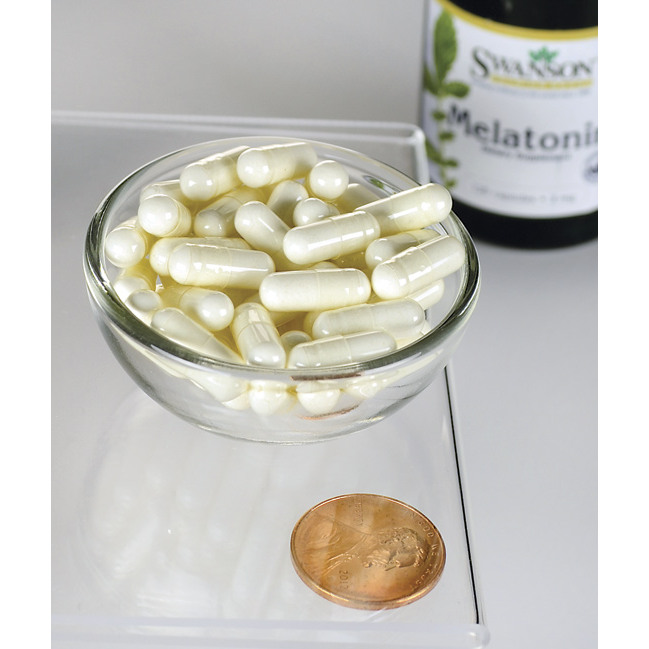 Swanson Astragalus Root - 470 mg 100 capsules in a bowl next to a penny.