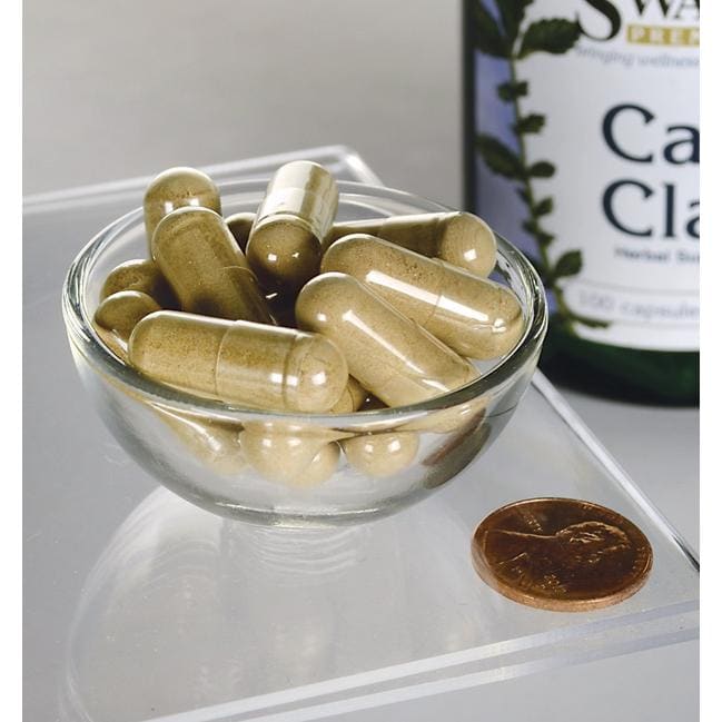 Cats Claw - 500 mg 100 capsules in a bowl next to a bottle of Swanson.