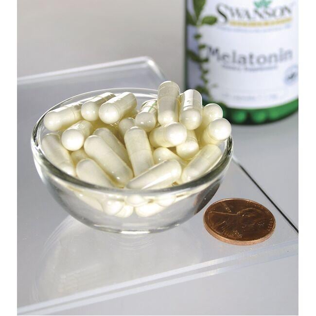 Swanson Melatonin - 1 mg 120 capsules in a bowl next to a bottle of Swanson Melatonin.