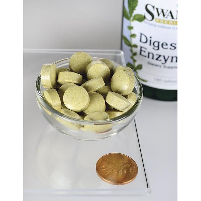 A bottle of Swanson Digestive Enzymes - 180 tabs and a penny in a glass bowl.