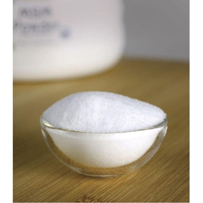 A bowl of Swanson MSM powder - 454 grams pwdr on a wooden table, promoting joint health and supporting collagen structures.