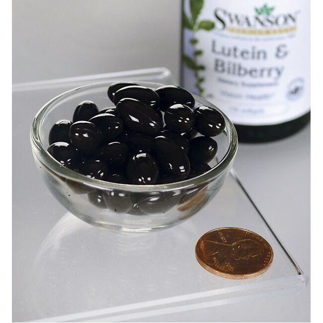 A glass bowl containing dark gel capsules next to a penny for scale, with a bottle of Swanson's Lutein Esters 6 mg & Bilberry 20 mg 120 Softgels for eye health in the background.