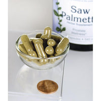 Thumbnail for Swanson Saw Palmetto - 540 mg 250 capsules, known for their role in promoting prostate health and urinary tract flow, are displayed in a bowl alongside a penny.
