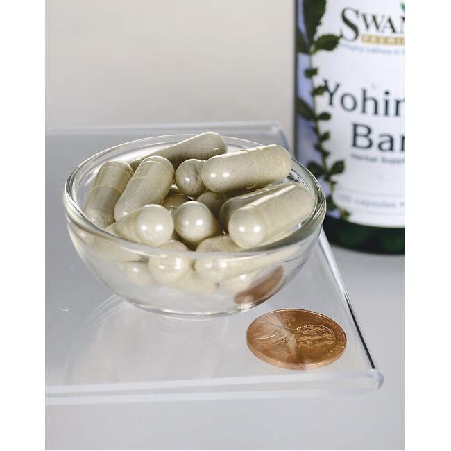 Swanson Yohimbe Bark - 75 mg 100 capsules in a glass bowl next to a penny.