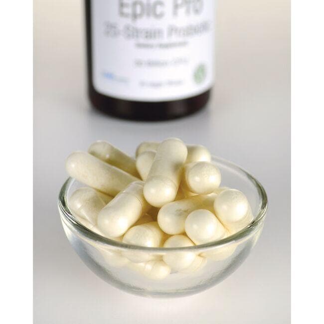 A bowl of white pills next to a bottle of Swanson's Epic Pro 25-Strain Probiotic - 30 vege capsules.