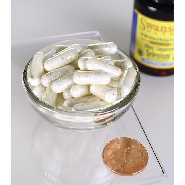 A bowl of Swanson Selenium Complex - 200 mcg 90 capsules Albion Chelated next to a penny demonstrating the bioavailability of selenium for cardiovascular disease.