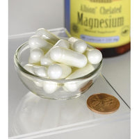 Thumbnail for A bottle of Swanson Magnesium - 133 mg 90 capsules Albion Chelated in a bowl next to a penny.