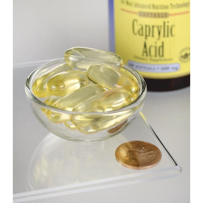 Swanson's Caprylic Acid - 600 mg 60 softgel dietary supplement capsules in a bowl next to a coin.