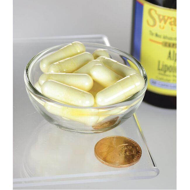A bowl of Swanson Alpha Lipoic Acid - 300 mg 60 capsules with a coin next to it.