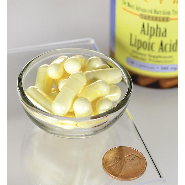 A bottle of Swanson Alpha Lipoic Acid - 300 mg 120 capsules sits next to a penny.