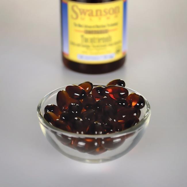 Swanson Tocotrienols - 50 mg 60 softgel capsules in a bowl next to a bottle, providing antioxidant support for healthy cholesterol levels.