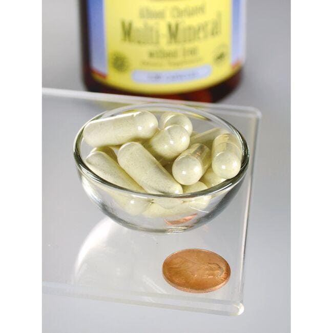 Multi-Mineral without Iron Albion capsules by Swanson in a bowl next to a bottle of vitamin c, utilizing Albion's breakthrough chelation technologies for highly absorbable mineral glycinates.