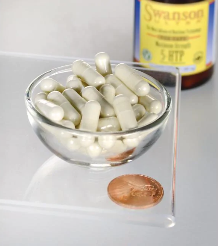 A bowl of Swanson 5-HTP Maximum Strength 200 mg 60 Capsules next to a penny.
