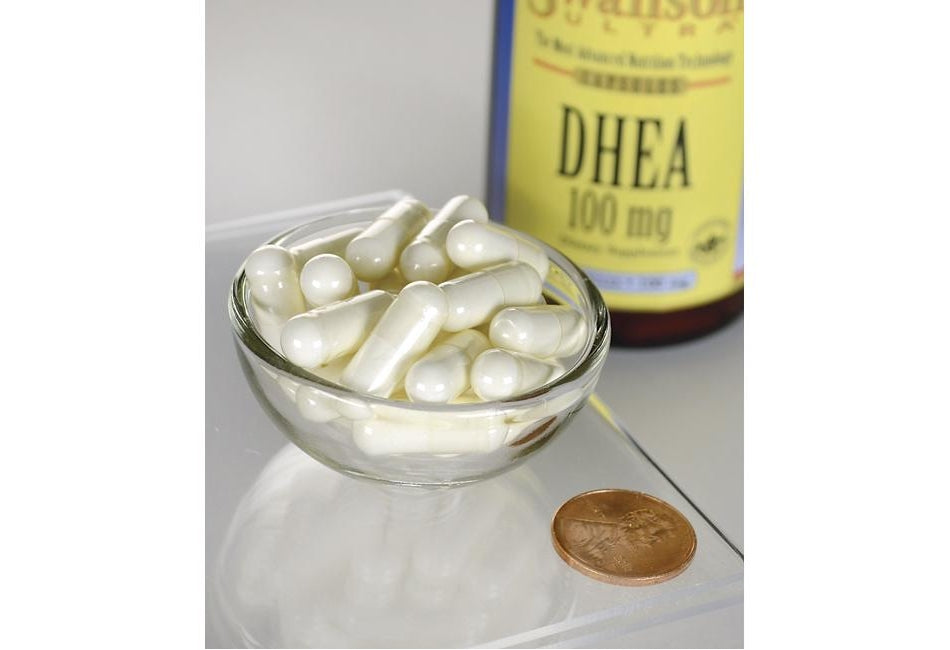 Swanson DHEA - 100 mg 60 capsules in a bowl next to a penny.
